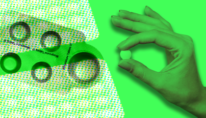 A packet of abortion medication next to a hand holding a medication tablet