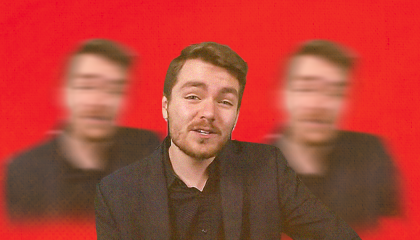 Image of Nick Fuentes superimposed upon three, blurrier Fuenteses in the background, with a red backdrop 