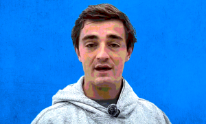 nick shirley in a gray hoodie before a blue background